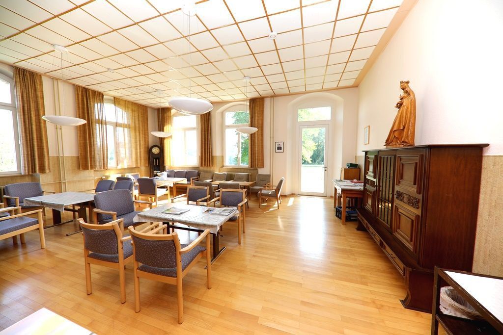 Der Speisesaal mit Holzboden und großen Fenstern