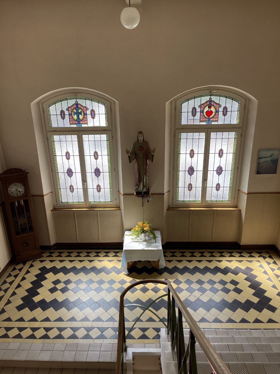 Treppenhaus mit bunten Glasfenstern und Fliesenboden
